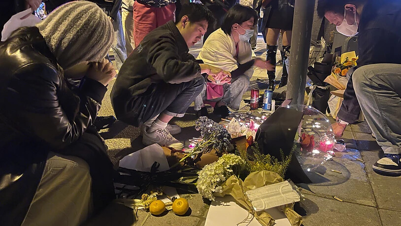 Anwohner legen Blumen und Kerzen nieder für die Opfer eines Brandes in einem Wohnhaus in der Stadt Urumqi. Aus Protest gegen die strengen Corona-Maßnahmen der chinesischen Regierung sind in der Provinz Xinjiang im Nordwesten des Landes Hunderte Menschen…