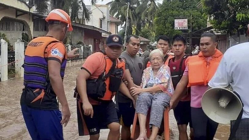 HANDOUT - Eine ältere Frau wird von Mitarbeitern der Küstenwache durch die Fluten in Plaridel getragen. Foto: Uncredited/Philippine Coast Guard/AP/dpa - ACHTUNG: Nur zur redaktionellen Verwendung im Zusammenhang mit der aktuellen Berichterstattung und…