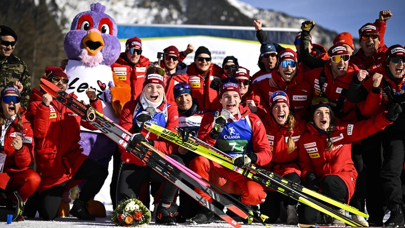 Guter Teamgeist: Das Schweizer Biathlonteam posiert mit den EM-Silbermedaillengewinnern Amy Baserga und Niklas Hartweg.
