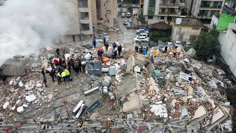 Notfallteams suchen nach Menschen in einem zerstörten Gebäude. Foto: DIA Images/AP/dpa