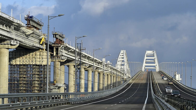 Autos und andere Fahrzeuge befahren die Krim-Brücke, die das russische Festland und die Halbinsel Krim über die Meerenge von Kertsch nach Restaurierungsarbeiten wieder verbindet. Foto: Uncredited/AP/dpa