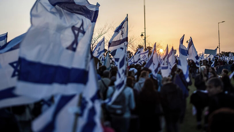 Demonstranten tragen israelische Fahnen während eines Protests in der Nähe der Knesset. Foto: Ilia Yefimovich/dpa