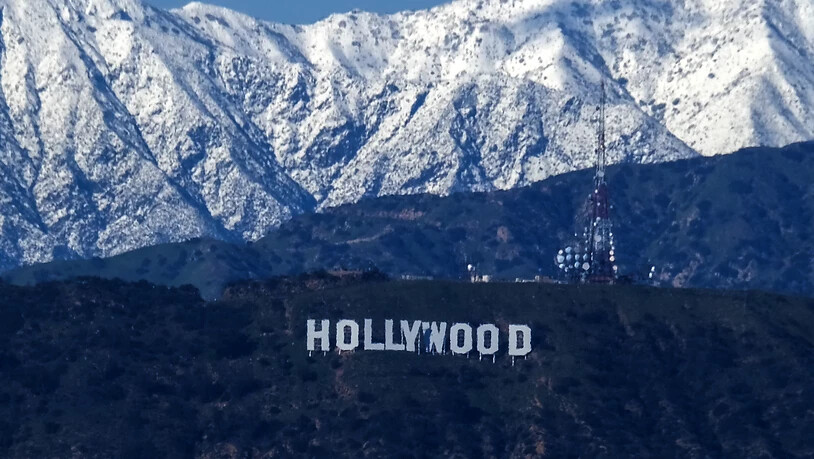 Nach einem seltenen Schneesturm in Südkalifornien sind die schneebedeckten San-Gabriel-Berge hinter dem Hollywood-Schild zu sehen. Foto: Ringo Chiu/SOPA Images via ZUMA Press Wire/dpa