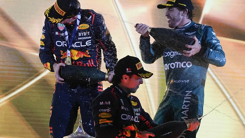 Weltmeister Max Verstappen (links) wird von Altmeister Fernando Alonso mit Champagner geduscht