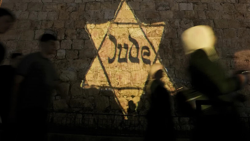 Ein gelber Davidstern mit der Aufschrift «Jude» wird auf die Mauern der Jerusalemer Altstadt projiziert. Foto: Mahmoud Illean/AP/dpa