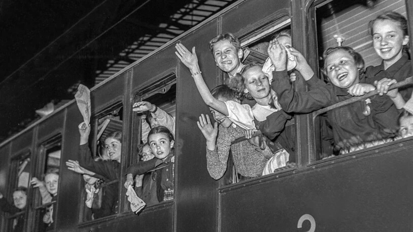 Pfingstreiseverkehr anno dazumals: Kinder winken 1950 im Bahnhof Basel SBB aus Dritte-Klasse-Wagen, die mit Holzbänken versehen waren.