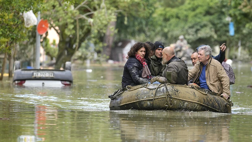 Menschen werden aus einer überschwemmten Region mit Schlauchbooten evakuiert. Foto: Luca Bruno/AP/dpa
