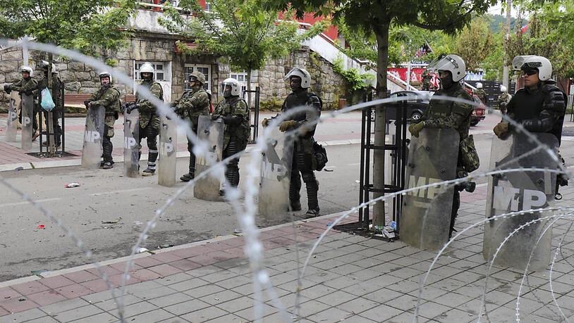KFOR-Soldaten stehen hinter Stacheldraht, den sie vor dem Rathaus in der Stadt Zvecan im Norden des Kosovo platziert haben. Foto: Bojan Slavkovic/AP