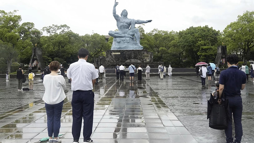 Besucher beten still für die Opfer des US-Atombombenabwurfs vor der Friedensstatue in Nagasaki, Südjapan, zum Zeitpunkt des Bombenabwurfs. Die Zeremonie fand in einem Innenraum statt und wurde wegen des herannahenden Tropensturms Khanun verkleinert. Foto…