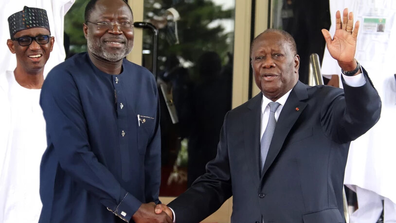 Omar Touray (l), Präsident der Ecowas-Kommission, begrüßt Alassane Ouattara, Präsident der Elfenbeinküste, zum Ecowas-Treffen. Foto: Gbemiga Olamikan/AP/dpa