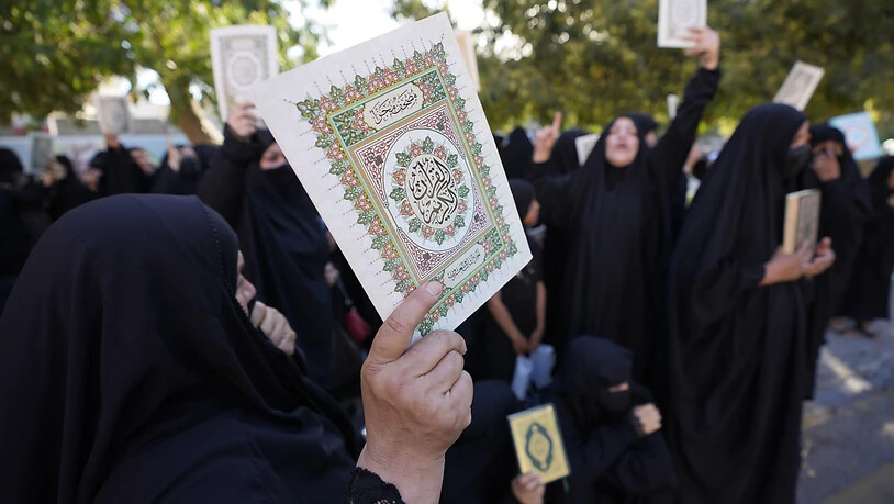 Irakische Frauen halten Kopien des Korans, des Heiligen Buches der Muslime, während einer Demonstration hoch. Foto: Hadi Mizban/AP/dpa