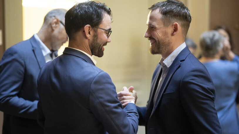 Thomas Tschudi (links), Vize-Präsident der Glarner SVP, gratuliert dem neu gewählten Nationalrat Markus Schnyder (SVP). 123 Männer und 77 Frauen sind am Sonntag in den Nationalrat gewählt worden.