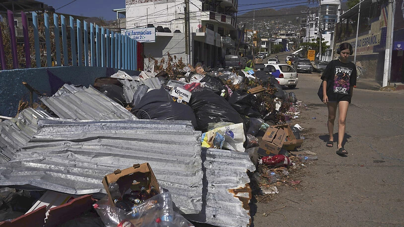 Eine Anwohnerin geht an den Trümmern vorbei, die der Hurrikan «Otis» verursacht hat. «Otis» traf Acapulco am 25. Oktober. Foto: Marco Ugarte/AP/dpa