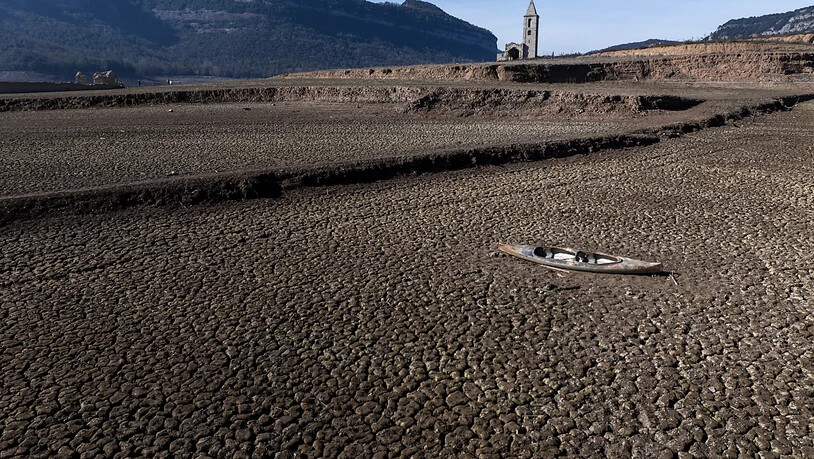 ARCHIV - Ein verlassenes Kanu liegt auf dem rissigen Boden des Sau-Stausees etwa 100 Kilometer nördlich von Barcelona. Die nordöstliche Region in Katalonien ist schwer von der Trockenheit betroffen. Foto: Emilio Morenatti/AP/dpa