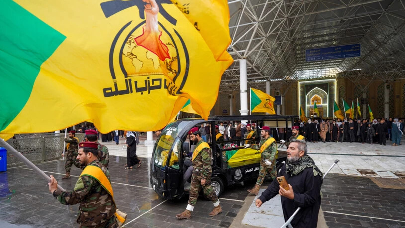 Mitglieder der Kataib Hisbollah nehmen an der Beerdigung von Kämpfern teil, die nach eigenen Angaben bei einem US-Luftangriff in der Provinz Qaim getötet wurden. Foto: Anmar Khalil/AP/dpa