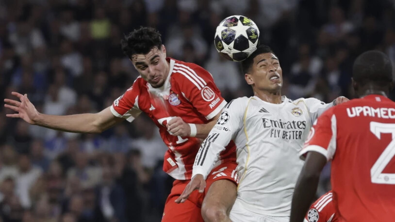 Real Madrids Jude Bellingham (rechts) im Zweikampf mit Bayerns Aleksandar Pavlovic