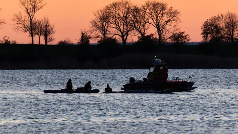 dpatopbilder - Helfer arbeiten in direkter Nähe des Wals. Der Buckelwal hat seine Position im flachen Wasser nicht wieder verlassen. Ein mehrköpfiges Team versucht den Wal wieder freizuspülen. Foto: Marcus Golejewski/dpa
