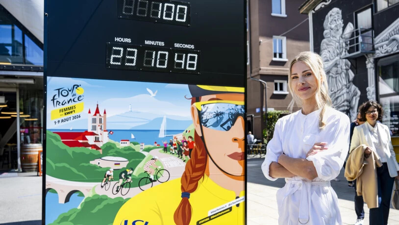 Marion Rousse, die Direktorin der Tour de France Femmes, steht neben der Affiche für die Austragung 2026 mit dem Countdown in Lausanne