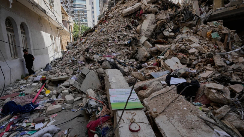 ARCHIV - Ein Junge geht an einem zerstörten Gebäude vorbei, das vor einer Woche bei einem israelischen Luftangriff im Zentrum von Beirut, getroffen wurde. Foto: Hussein Malla/AP/dpa
