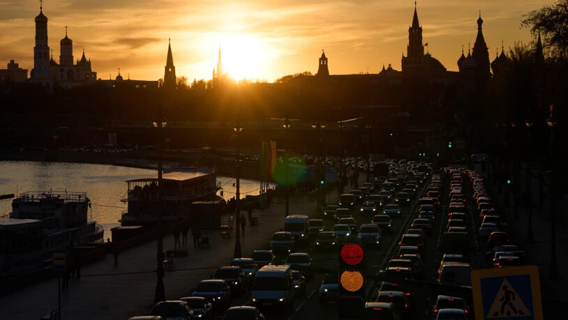 Autos fahren bei Sonnenuntergang am Moskvoretskaya-Ufer des Moskwa-Flusses entlang, im Hintergrund der Kreml. Foto: Alexander Zemlianichenko/AP/dpa