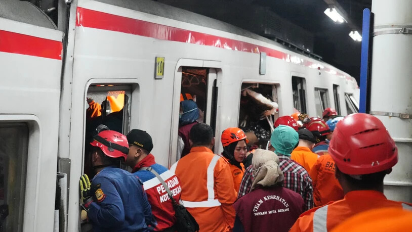 Rettungskräfte suchen nach einer Zugkollision in einem Bahnhof in Bekasi, Indonesien, nach Opfern. Foto: Ahmad Ibrahim/AP/dpa