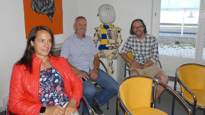 Die Landräte Seraina Mani und Christian Thomann (EVP) sowie Markus Suter (r.) von Davos Instruments flankieren «Roboy», der 2013 im AI-Labor der ETH entstand und nun das Maskottchen des «Lab42» ist.