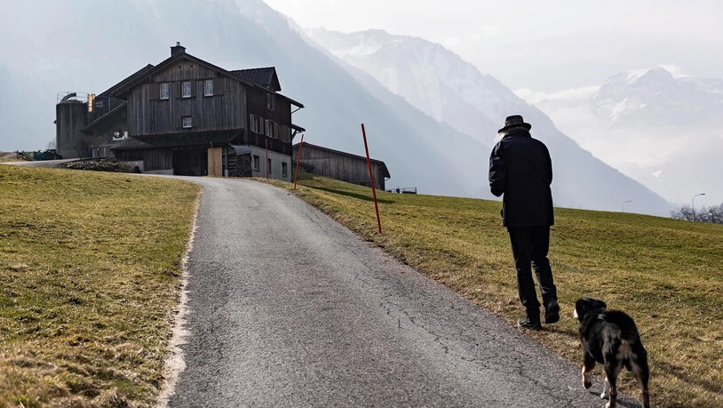 Ein Mann geht in Hätzingen mit seinem Hund spatzieren.