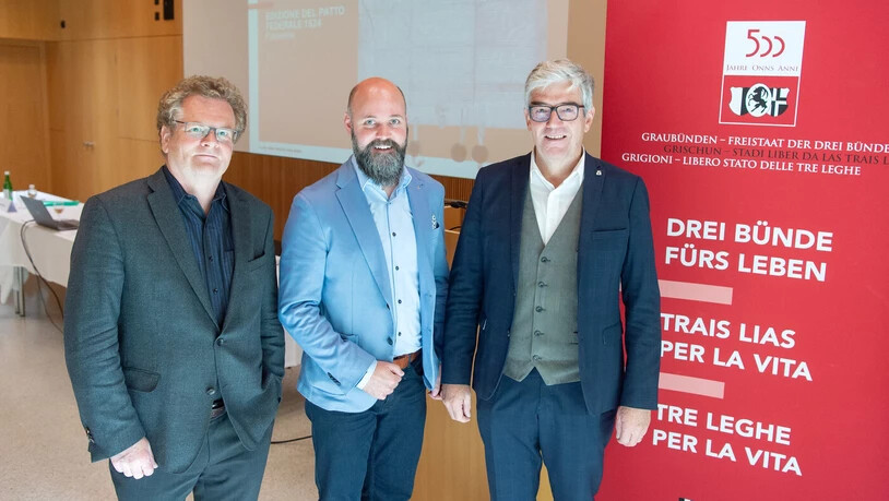 Startschuss: Vor einer Projektion des Bundsbriefs von 1524 stellt Regierungsrat Jon Domenic Parolini (rechts) zusammen mit Staatsarchivar Reto Weiss (links) und Projektleiter Daniel Camenisch das Programm für die Jubiläumsfeierlichkeiten vor.
