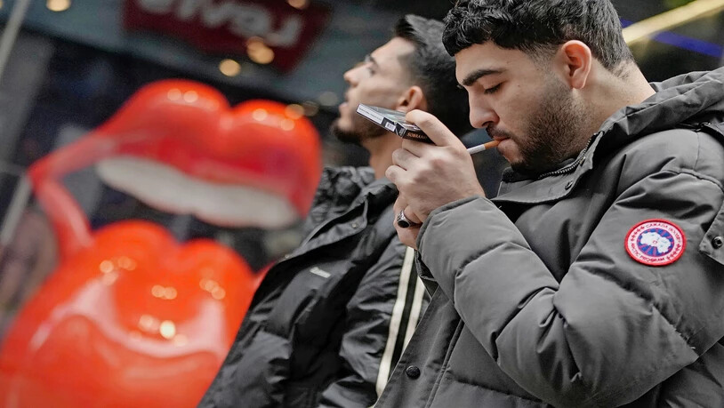 In der Hektik des Alltags: Ein junger Mann zündet sich in den Strassen der britischen Millionenmetropole London eine Zigarette an. 