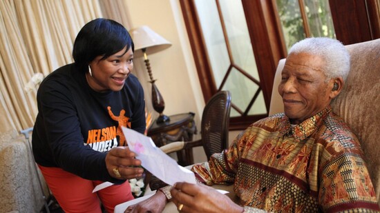 ARCHIV - HANDOUT - Nelson Mandela, 2013 verstorbener südafrikanischer Freiheitskämpfer, zeigt seiner jüngsten Tochter Zindzi Mandela einen Brief, in dem ihm zum 92. Geburtstag gratuliert wird. Zindziswa «Zindzi» Mandela ist tot. Foto: Debbie Yazbek/…