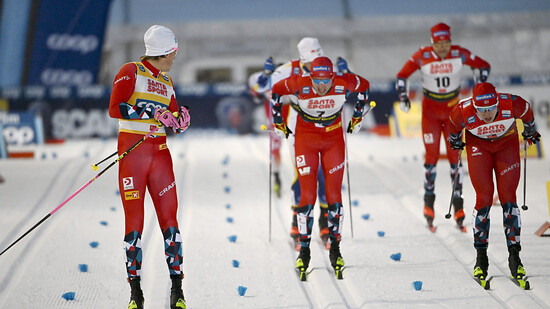 Johannes Hösflot Klaebo, hier kurz vor dem Sieg beim Sprint in Kuusamo, schaut zurück. Er sieht fast nur Teamkollegen im roten Dress.