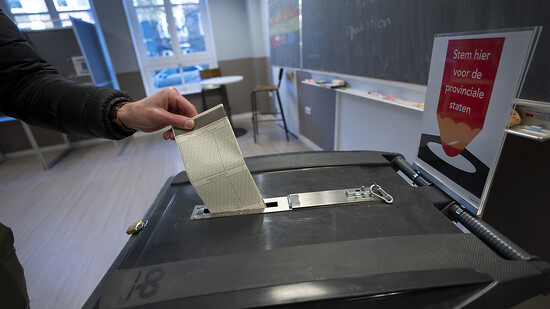 Ein Mann gibt in Amsterdam seinen Stimmzettel für die Provinzwahlen ab. Foto: Peter Dejong/AP/dpa