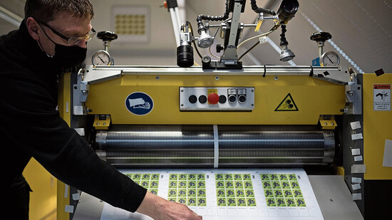 Eine Druckerei in Liechtenstein stellt einen Teil der Schweizer Briefmarken her: Ein Mitarbeiter nimmt Piatti-Sonderbriefmarken aus der Stanzmaschine.