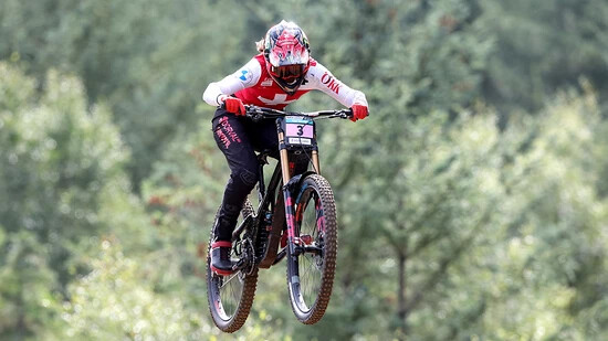 Camille Balanche fliegt mit dem Downhill-Bike durch die Luft