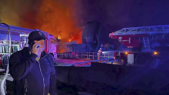 HANDOUT - Michail Raswoschajew spricht in ein Mobiltelefon, während Rauch und Flammen aus einer brennenden Werft auf der Krim aufsteigen. Mehrere Marschflugkörper sind nach offiziellen russischen Angaben über der seit 2014 von Russland annektierten Krim…