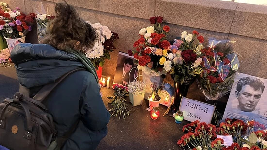 Menschen legen Blumen an der Stelle nieder, an der 2015 der Kremlgegner Boris Nemzow erschossen wurde. Foto: Hannah Wagner/dpa