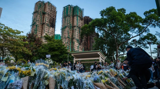 Trauernde legen nach dem tödlichen Brand Blumen an einer behelfsmäßigen Gedenkstätte in der Nähe des Wohnkomplexes Wang Fuk Court in Tai Po nieder. Foto: Vernon Yuen/Nexpher via ZUMA Press Wire/dpa