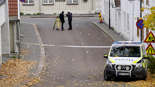 ARCHIV - Zwei Polizisten ermitteln am 14.10.2021 in der Nähe des Tatorts nach einer Gewalttat in der norwegischen Kleinstadt Kongsberg. Zum Start des Prozesses um den Fünffachmord in Kongsberg hat der Angeklagte die Tat gestanden. Das berichtete die…