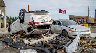 Zwei stark beschädigte Fahrzeuge stehen nach einem Tornado auf dem Parkplatz von Hobby Lobby nahe des Michigan State Highway 32. Foto: Jake May/MLive.com/The Flint Journal via AP/dpa - ACHTUNG: Nur zur redaktionellen Verwendung und nur mit vollständiger…