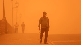 Ein Mann läuft während eines Sandsturms über eine Brücke in der irakischen Hauptstadt Bagdad.