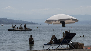 Menschen geniessen das sommerliche Wetter im Strandbad Mythenquai in Zürich.