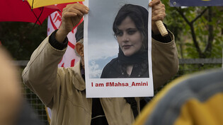 Bei einem Protest des Nationalen Widerstandsrates Iran (NWRI) vor der iranischen Botschaft in Berlin hält ein Mann ein Bild der verstorbenen Mahsa Amini in Händen. Foto: Paul Zinken/dpa - ACHTUNG: Nur zur redaktionellen Verwendung und nur mit…