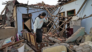 Eine Frau inspiziert ihr Haus, das bei einem Erdbeben in Cianjur schwer beschädigt wurde. Foto: Tatan Syuflana/AP/dpa