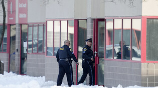Polizisten gehen in Des Moines, Iowa, in das Gebäude von Starts Right Here. Foto: Charlie Neibergall/AP/dpa