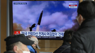 Eine Nachrichtensendung zeigt ein Archivbild eines Raketenstarts in Nordkorea in einem Beitrag der im Bahnhof in Seoul ausgestrahlt wird. Foto: Ahn Young-Joon/AP/dpa