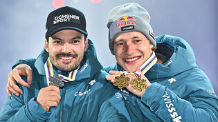 Loïc Meillard (links) und Marco Odermatt zeigen ihre Medaillen