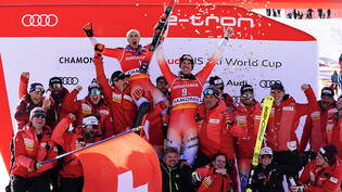 Der drittklassierte Daniel Yule (Startnummer 1) und Sieger Ramon Zenhäusern (9) jubeln nach dem Slalom in Chamonix mit den Trainern und Betreuern von Swiss-Ski