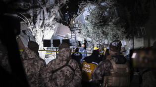 Mitglieder eines Rettungsteams suchen nach Menschen in einem zerstörten Gebäude. Foto: Ugur Yildirim/DIA/AP/dpa