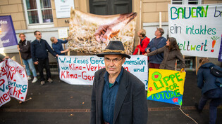 Der von Greenpeace unterstützte Landwirt Ulf Allhoff-Cramer - hier mit Demonstranten vor dem Landgericht - sieht sich durch die Geschäftstätigkeit von VW persönlich beeinträchtigt. (Archiv)