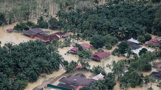 Diese Luftaufnahme aus einem Hubschrauber der malayischen Feuerwehr zeigt ein überschwemmtes Gebiet, nach anhaltenden Regenfällen. Foto: Amirul Azmi/BERNAMA/dpa